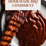 A close-up photo of barbecue ribs glazed with a dark spicy bbq sauce.