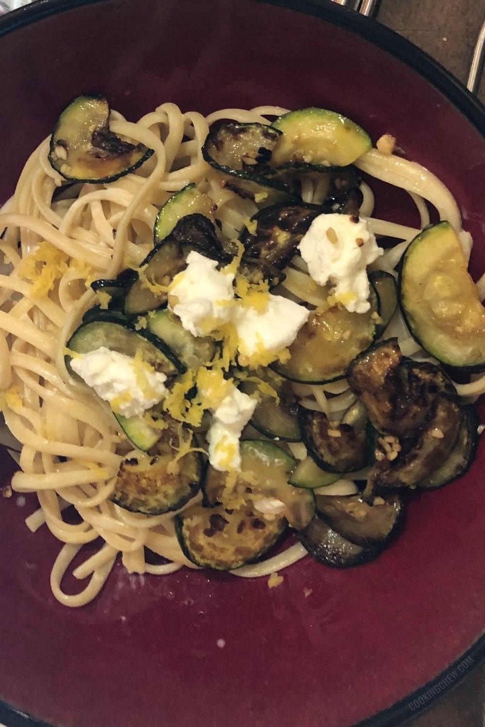 A plate of pasta with zucchini and goat cheese.