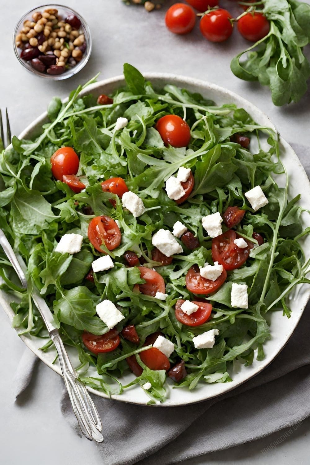 A colorful salad made with arugula, cherry tomatoes, and crumbled feta cheese.