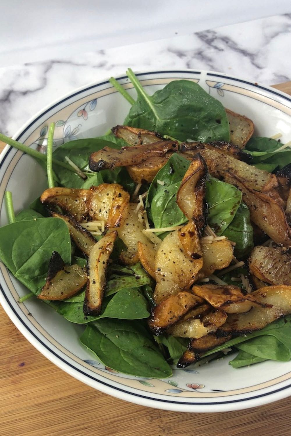 A gourmet pear salad with mixed greens, walnuts, and balsamic drizzle