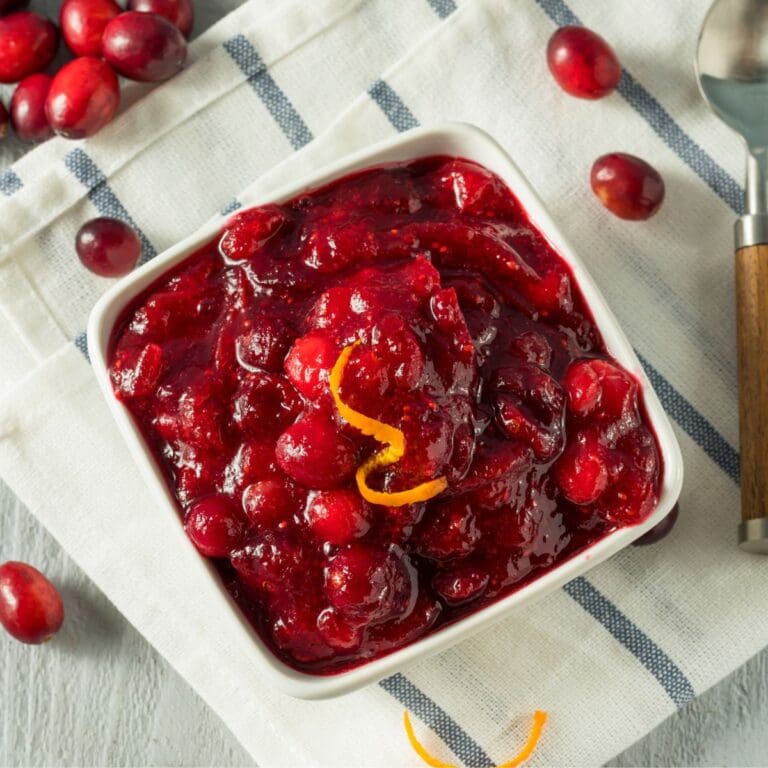 A close-up of a bowl of Classic Cranberry Pear Sauce on a table cloth.