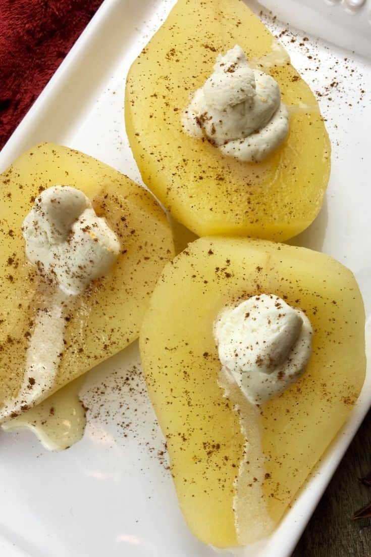 Closeup of fresh pear halves with a creamy goat cheese center, sprinkled with cinnamon