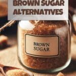 A glass jar filled with brown sugar next to a wooden spoon.