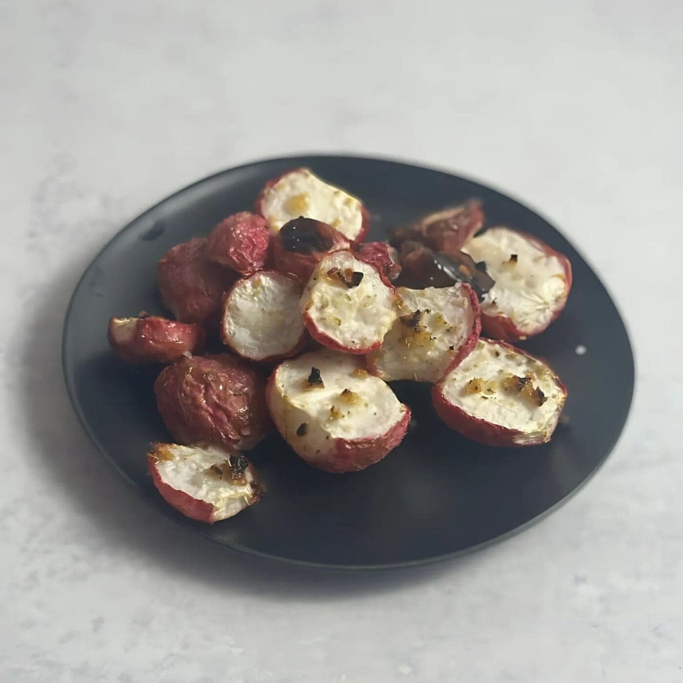 Crispy oven roasted radishes on a baking sheet.
