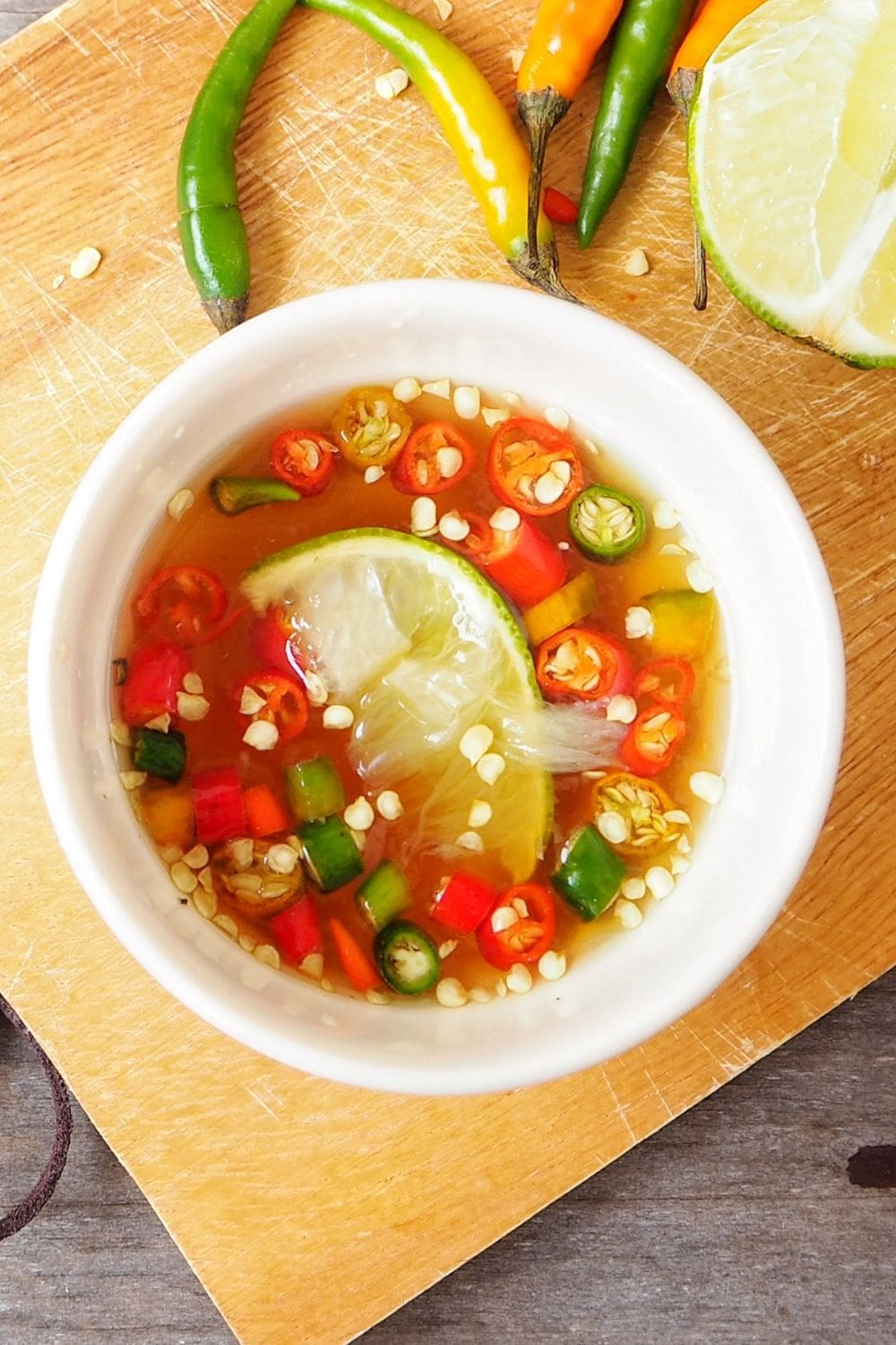 A bowl of fish sauce on a wooden table.