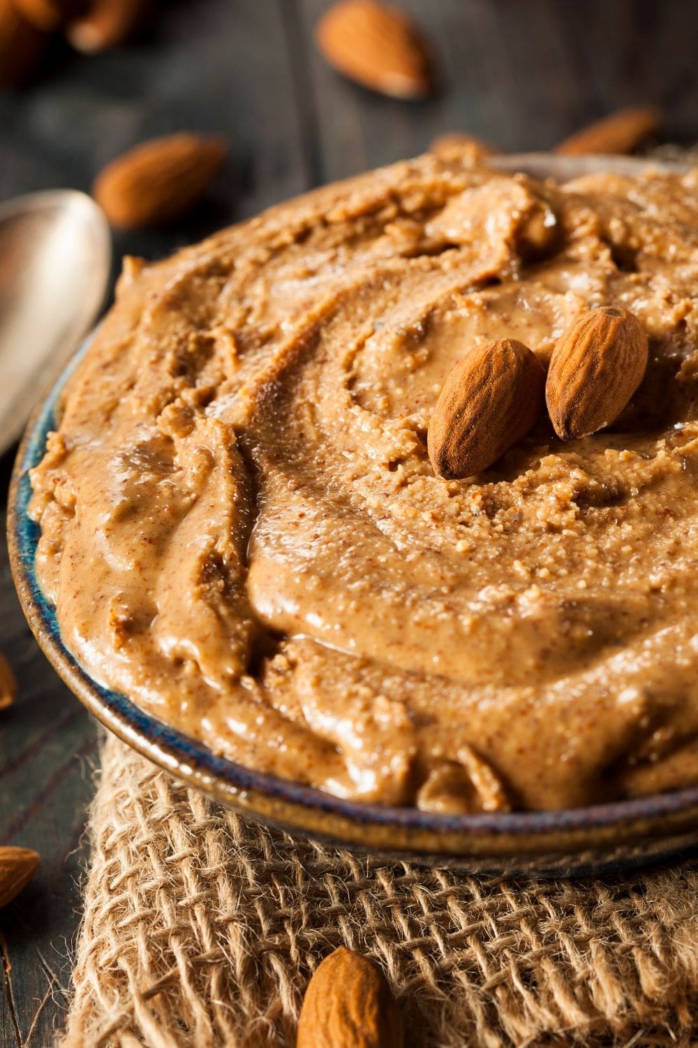 A photo of a bowl of almond butter topped with almonds.