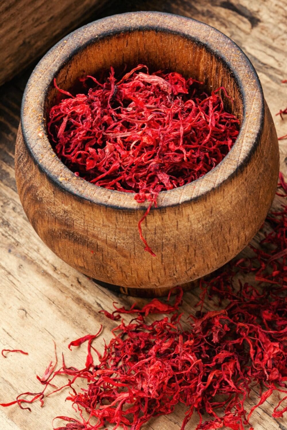 A photo of a wooden bowl filled with saffron threads.