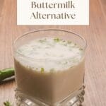 A glass of buttermilk on a wooden table.