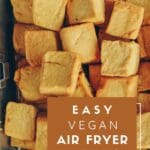 A close-up photo of a tray of air-fried tofu cubes in a basket-style air fryer.