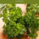 A bunch of parsley sitting on top of a wooden table.