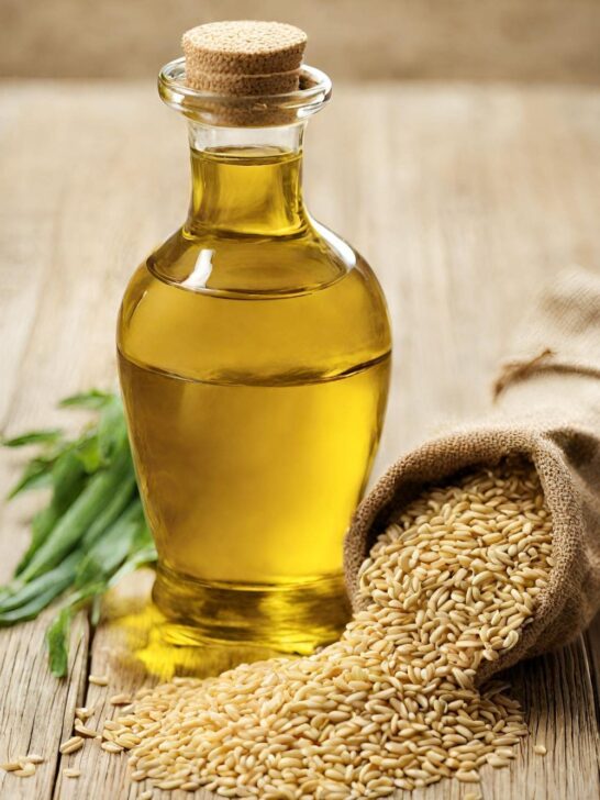 A bottle of sesame oil and a bag of rice on a wooden table.