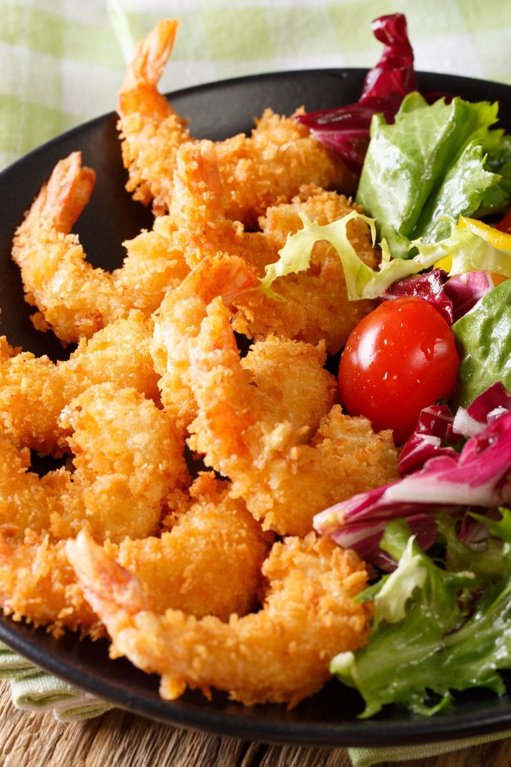  A close-up photo of a plate of old bay fried shrimp and a salad. 