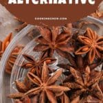 A close-up photo of a glass bowl filled with star anise pods on a wooden table.