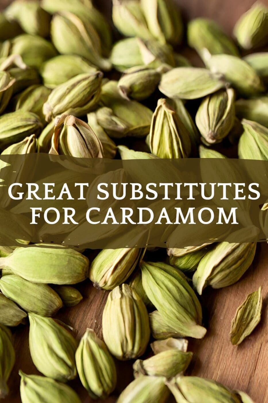 A close-up photo of a pile of cardamom seeds on a light wooden table.