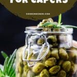 A close-up still life of a glass jar containing pickled capers.