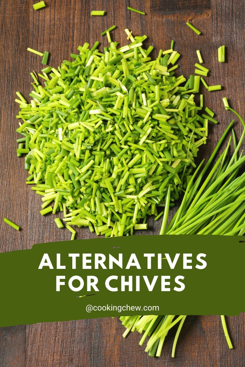 A close-up photo of a pile of chopped chives on a wooden cutting board.