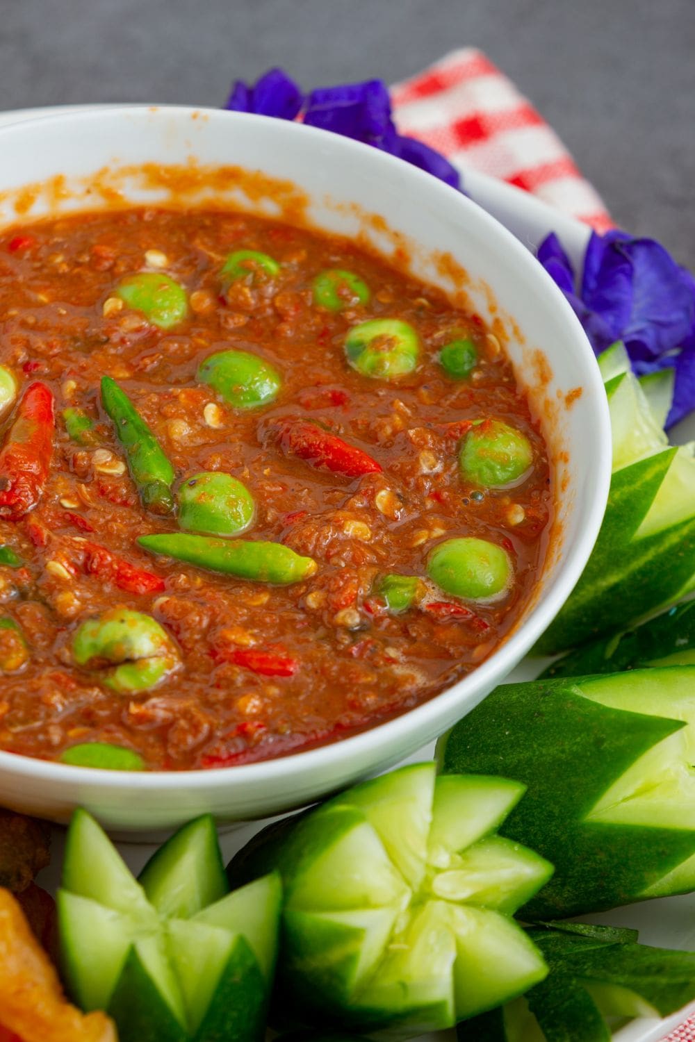A close-up photo of a small, white ceramic bowl filled with chili sauce.