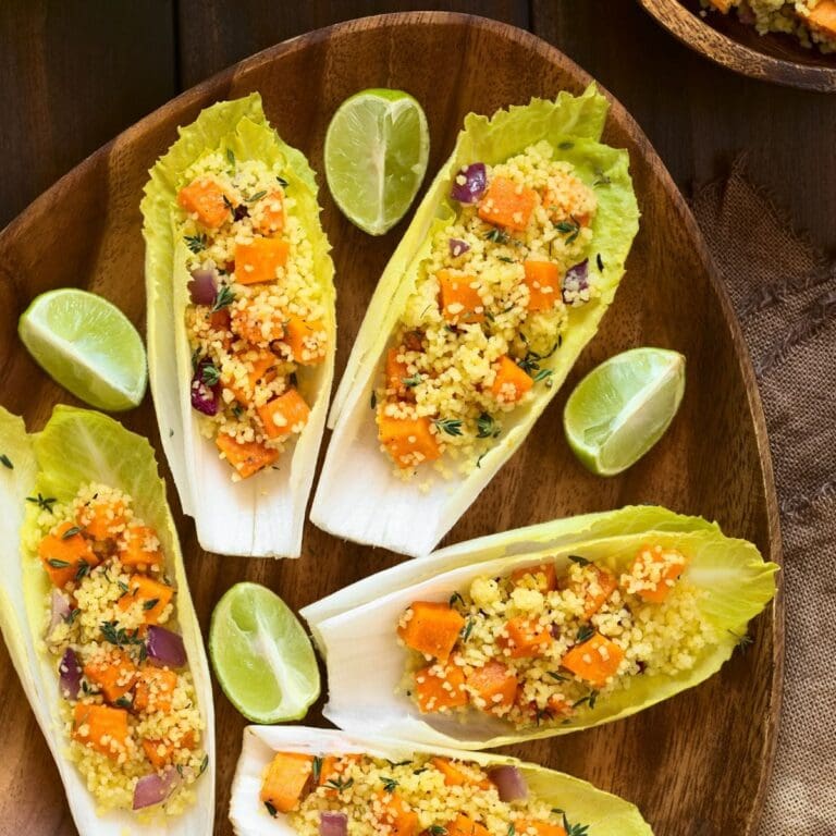 Endives leaves filled with a salad of couscous,pumpkin and red onion, sprinkled with fresh thymes leaves.