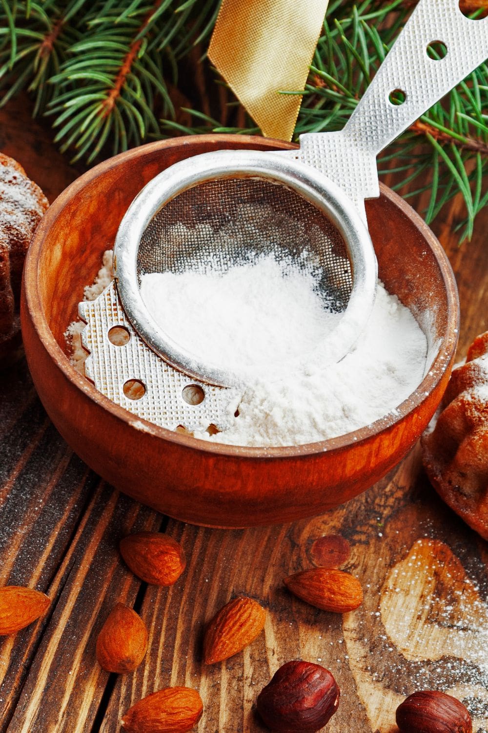 A wooden bowl filled with powdered sugar and nuts.
