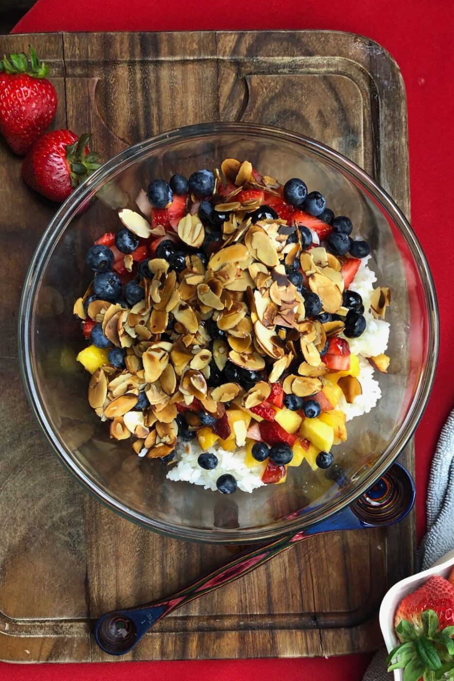 A colorful rice and fruit salad in a bowl, featuring fresh berries, citrus, and herbs for a refreshing summer dish.