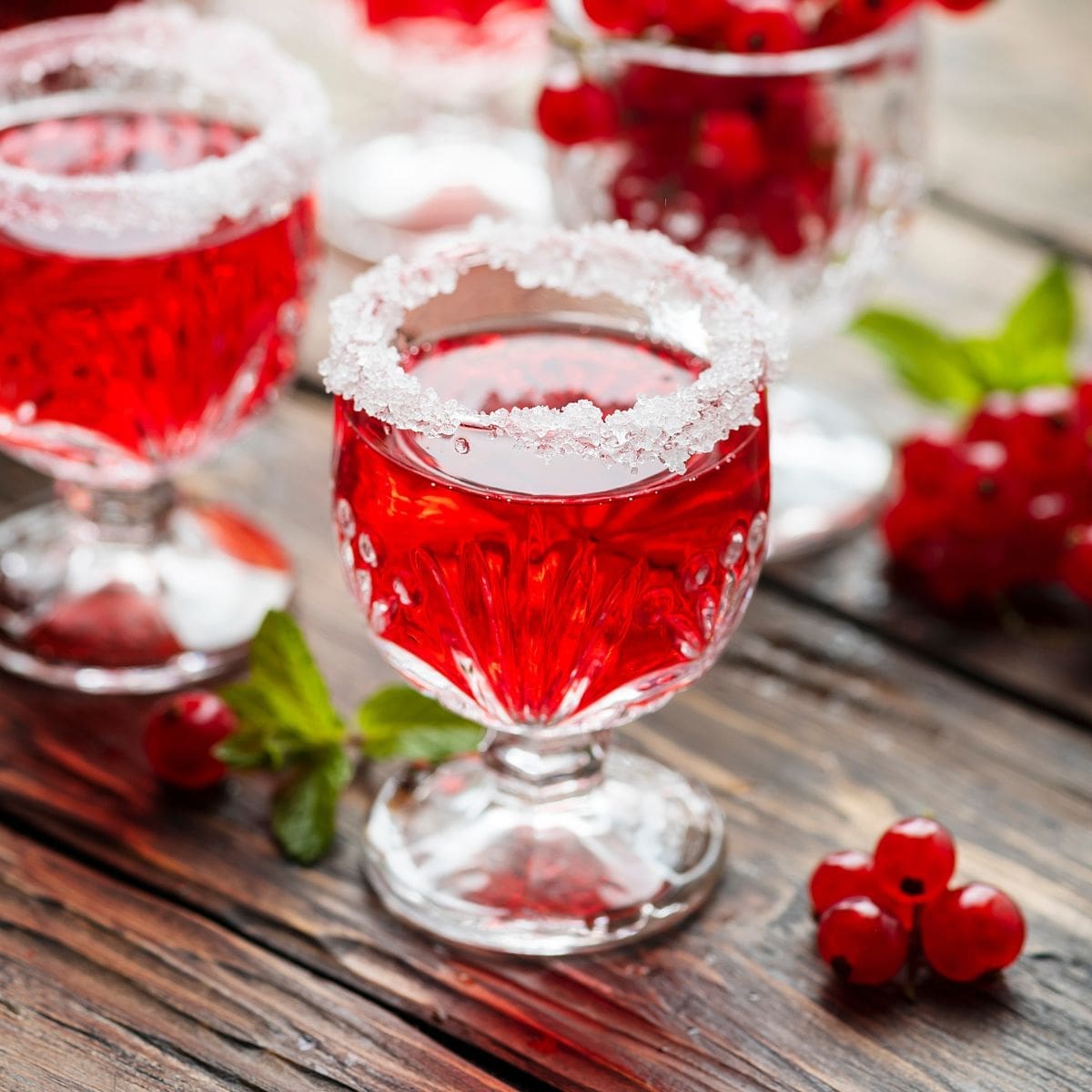 The image shows a close up of a glass cranberry prosecco cocktail.