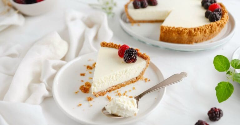 A beautifully presented no bake cheesecake with a graham cracker crust, topped with fresh berries and whipped cream. Perfect for a quick and easy dessert.