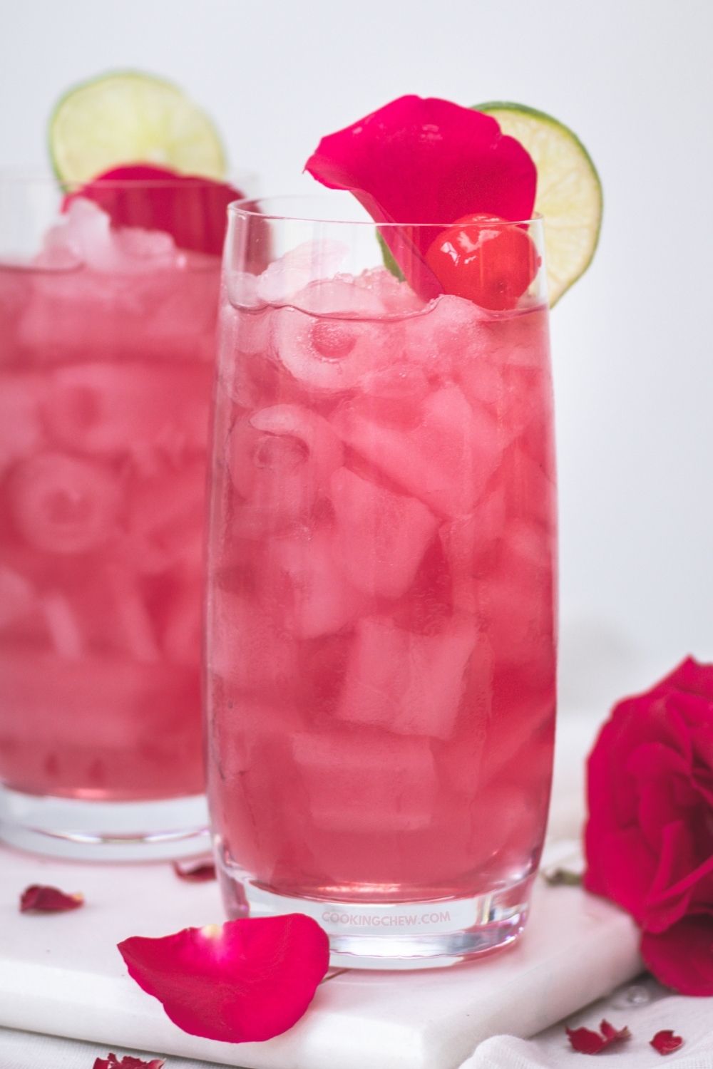 A glass of Ultimate Cranberry Vodka Cocktail garnished with a cranberry and a lime wedge. 