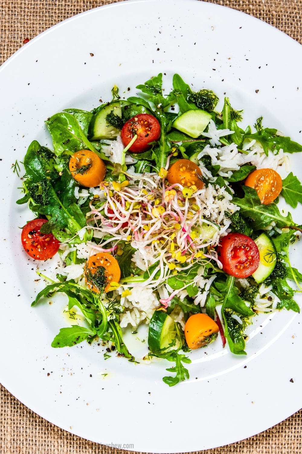 The image shows a plate of arugula salad with Parmesan cheese, croutons, and a Caesar dressing.
