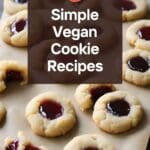 A stack of vegan thumbprint cookies with raspberry jam filling, arranged on a rustic wooden table.