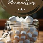 A glass jar filled with marshmallows on a wooden table.