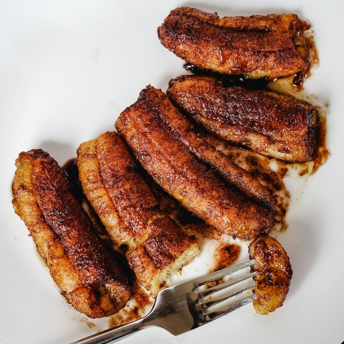 Cooked bananas fresh out of the air fryer, coated with brown sugar and cinnamon.