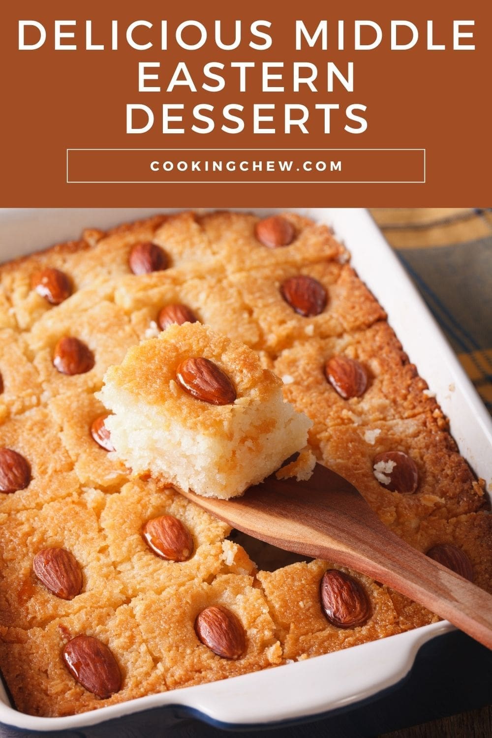 A close-up photo of a wooden spoon holding a slice of basbousa.