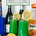 A close-up of two green mimosa drinks in glasses on a wooden table.