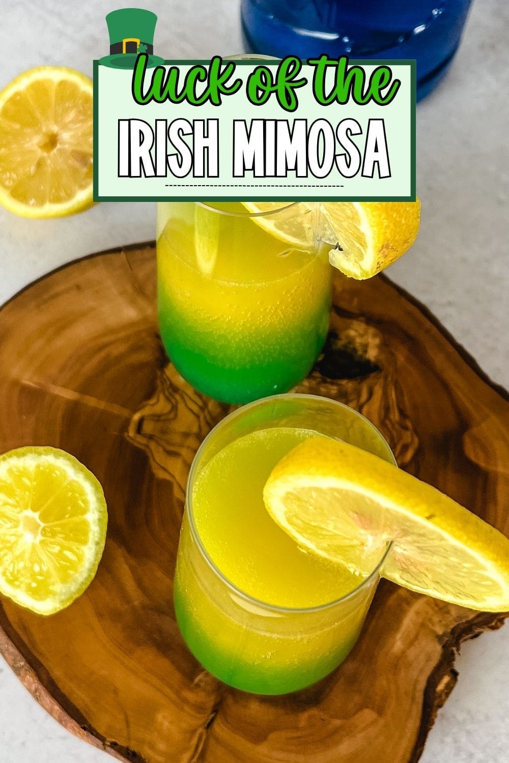 Two glasses of Irish mimosa with lemon slices on a wooden tray. 