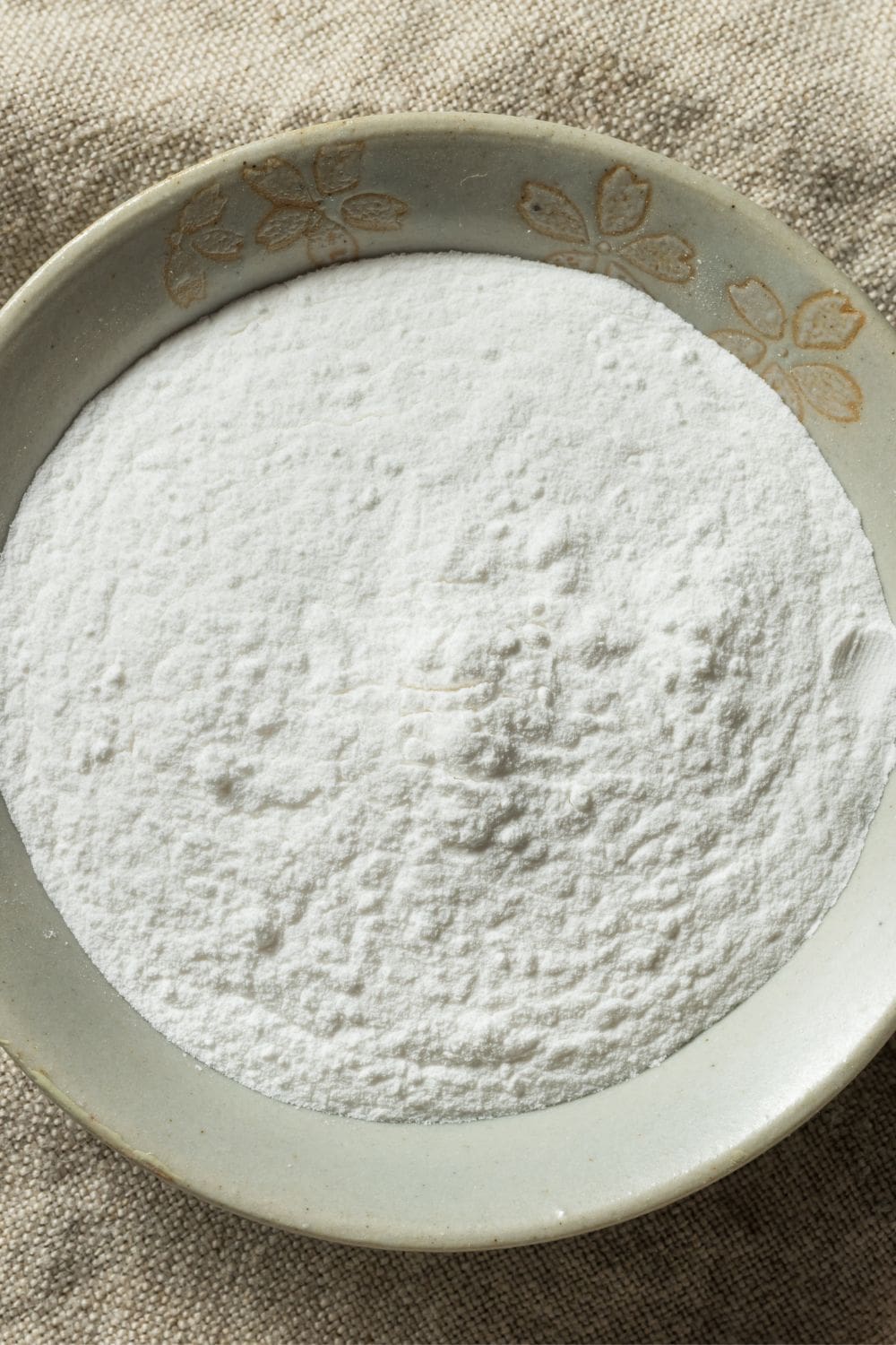 A close-up of a bowl of cream of tartar. 