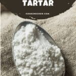 A photo of a measuring spoon filled with cream of tartar powder.