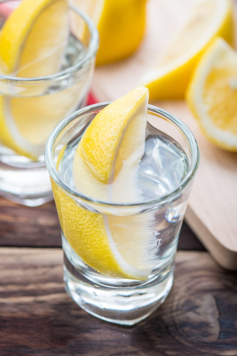A close-up photo of a lemon vodka cocktail in a glass garnished with a lemon slice.