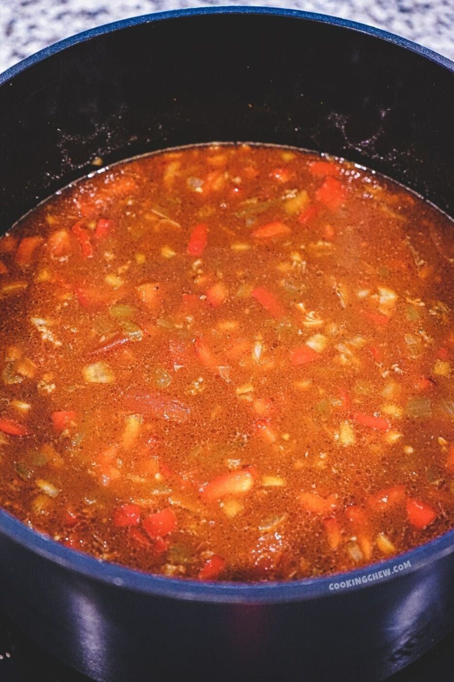 A close-up view of a pot taco soup simmering on a stovetop. 