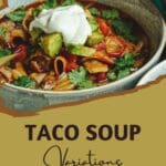 A close-up photo of a hearty and flavorful taco soup with a dollop of cooling sour cream, a half avocado, and fresh cilantro leaves.