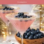A festive table setting with a blueberry sparkler glass and a bowl of blueberries