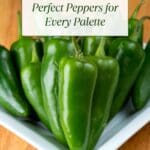 A stack of green bell peppers of various sizes sits on a white plate.