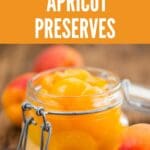 A glass jar of homemade apricot preserves sits on a rustic wooden table.