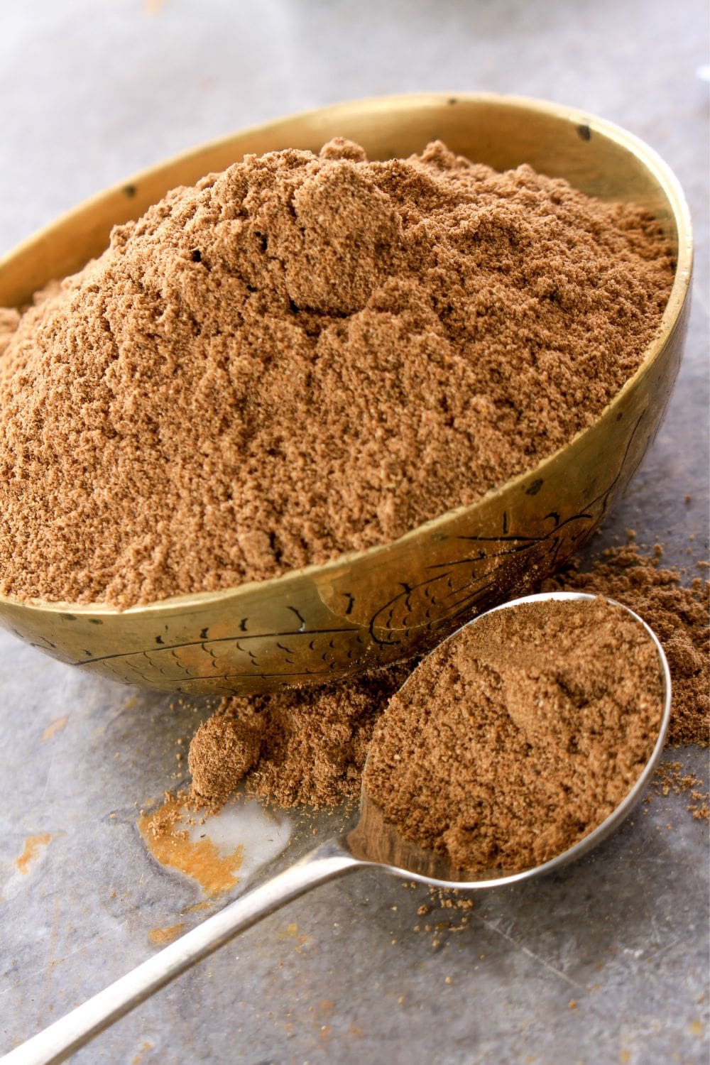 A bowl and spoon of garam masala.