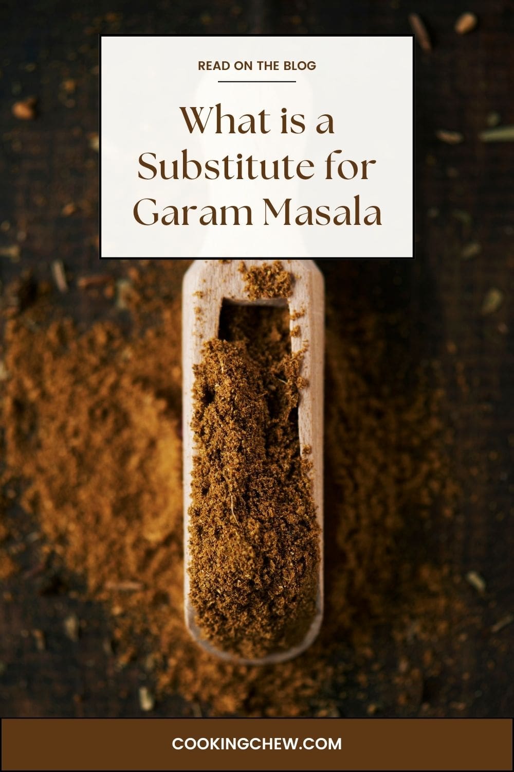 A wooden spoon filled with garam masala powder on a wooden table.