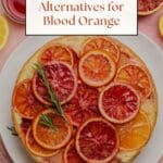 A photo of a white cake topped with slices of blood orange.