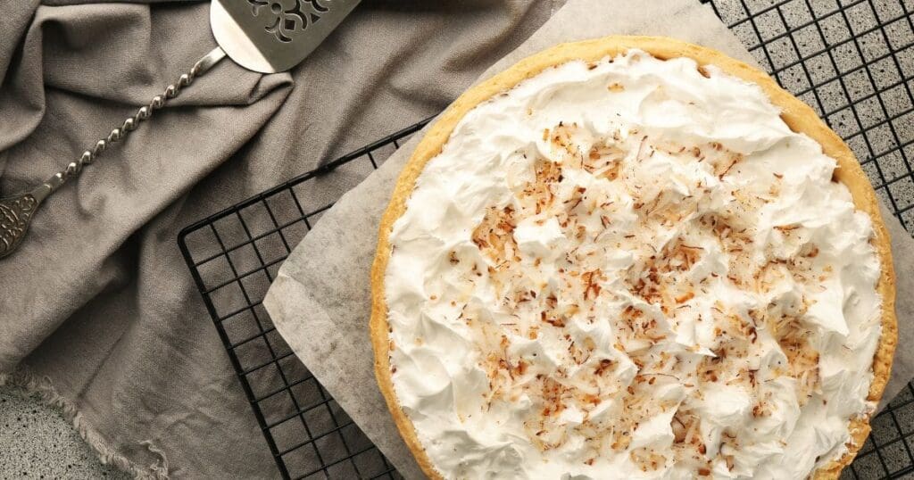 Cooked coconut cream pie on a wire cooling rack