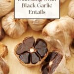 A close-up photo of two heads of black garlic, one whole and one peeled, revealing its soft, sticky cloves.