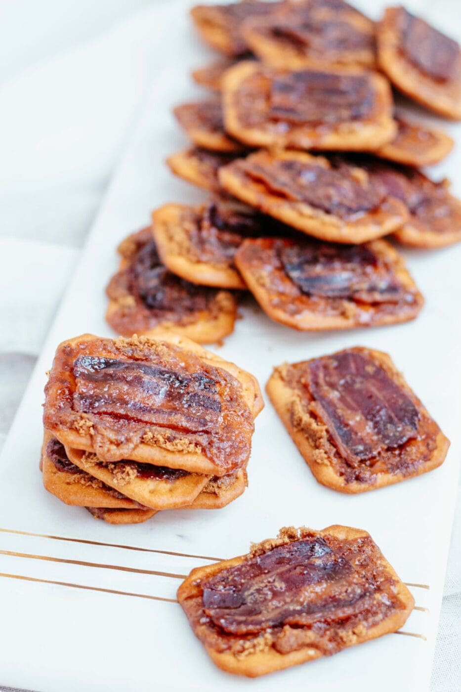 Bacon crackers spilled across a white plate. 