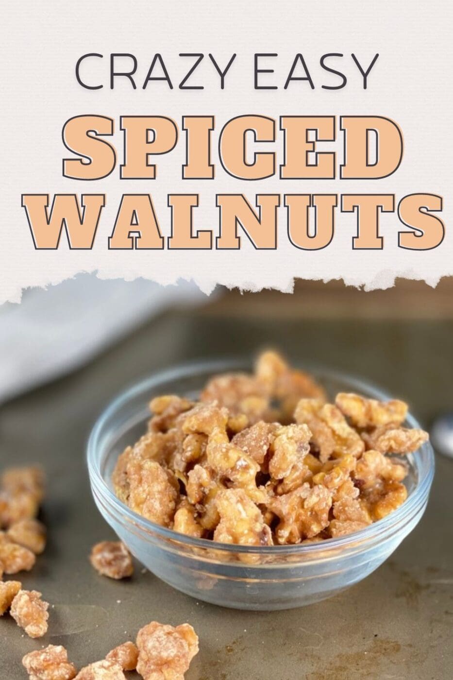Spiced walnuts in a small glass bowl sitting on a table