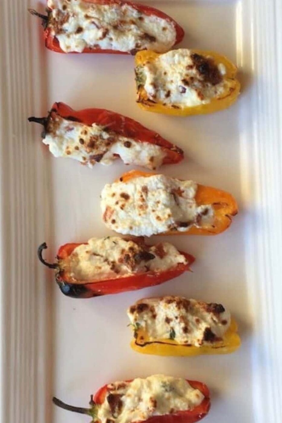 Stuffed mini peppers on a white plate. 